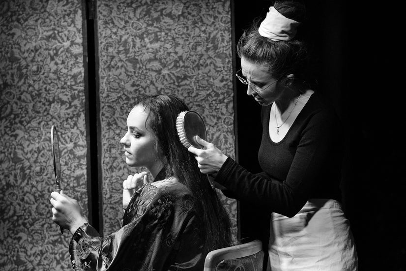 The maid pulls at Emilia's hair.