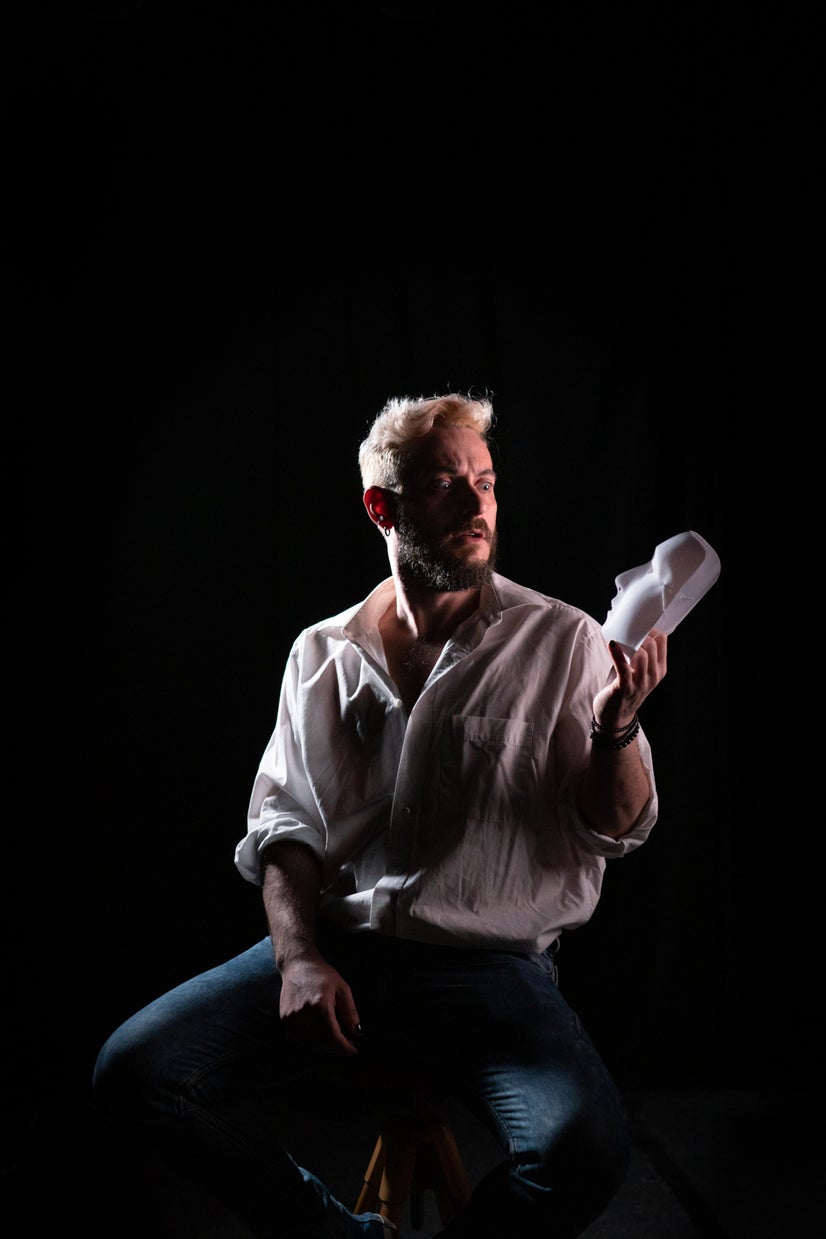 A photo of Klaus looking at a mask in his hand.