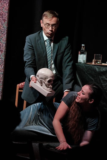 Dr. Kolenaty threatens Emilia Marty with a skull.