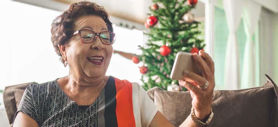 Asian elderly woman opening a gift or present at Christmas. Happy