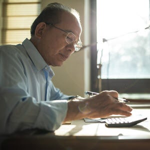 Man paying bills with calculator