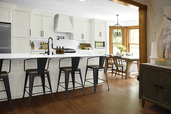 A white-on-white kitchen with modern barstools.