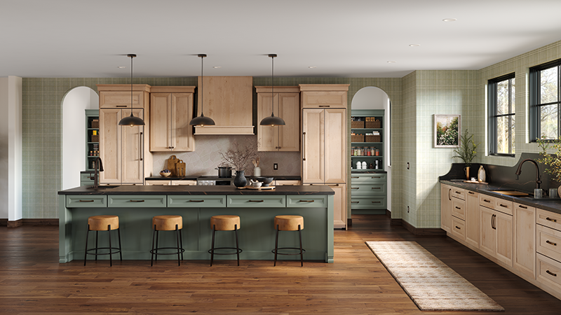 A kitchen with sage green and wood tone finishes on the island and cabinets.