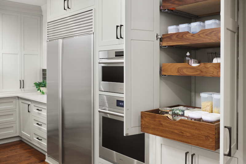 A kitchen pantry featuring several wooden roll trays to hold food, spices, and other items.
