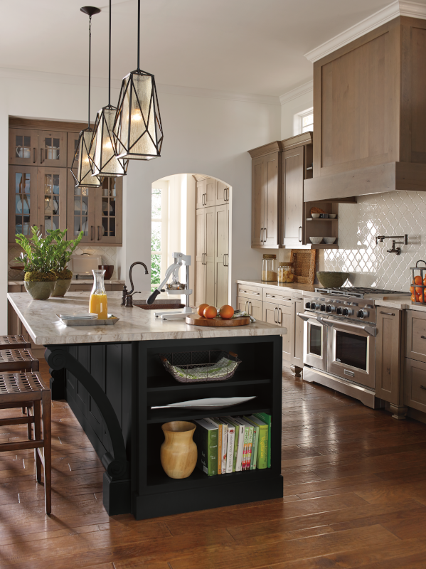 A kitchen with an island that offers dining space as well as storage for dishware and cookbooks.