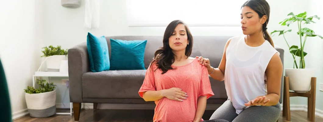 Beautiful midwife teaching breathing exercises for childbirth. Find Midwife Liability Insurance.