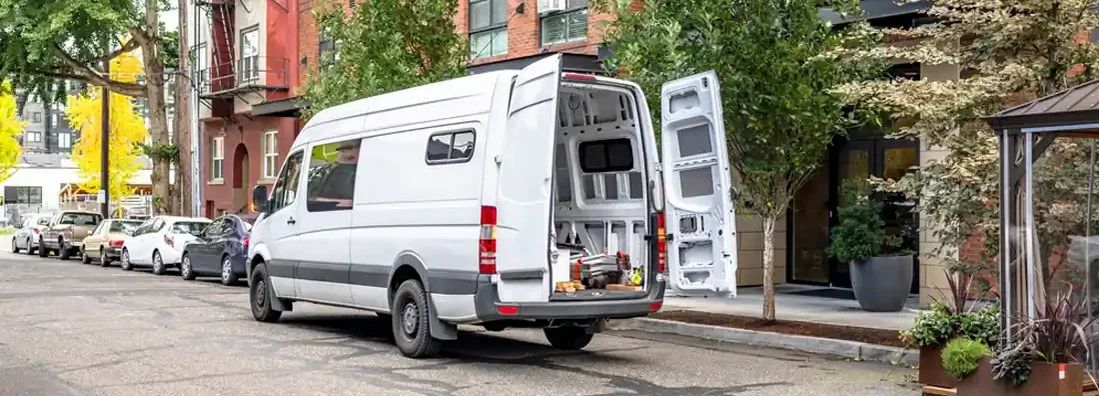 Compact mini van on an urban busy city street. Find Commercial Van Insurance.