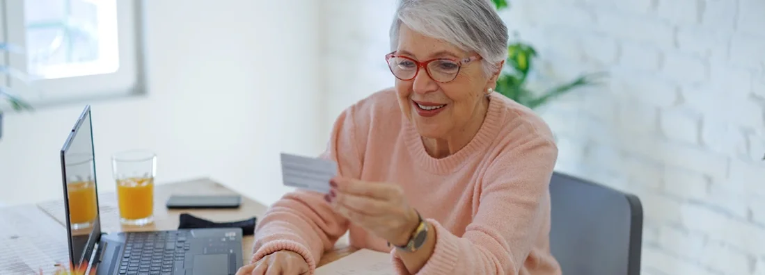 Woman online using laptop with insurance card. Car Insurance Policy Number. 