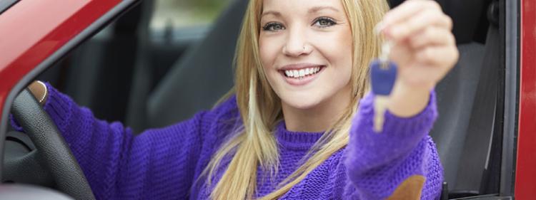 Happy teenage girl shows off the key to her new car.