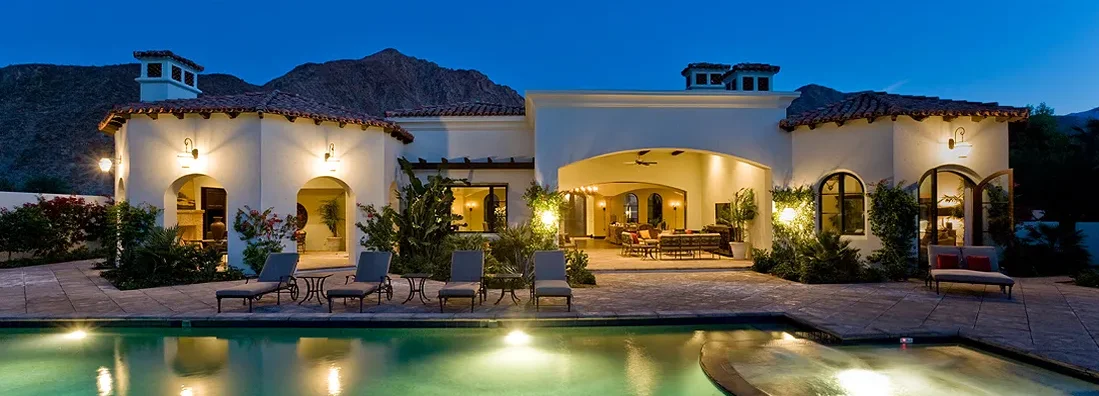 Backyard with illuminated swimming pool at dusk. How to Find the Best Homeowners Insurance in Glendale, Arizona.