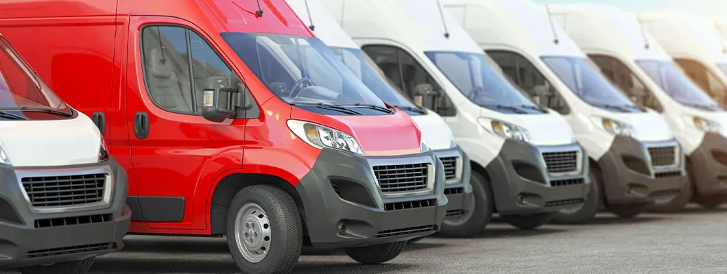Red delivery van in a row of white vans. Find Ohio Commercial Vehicle Insurance.