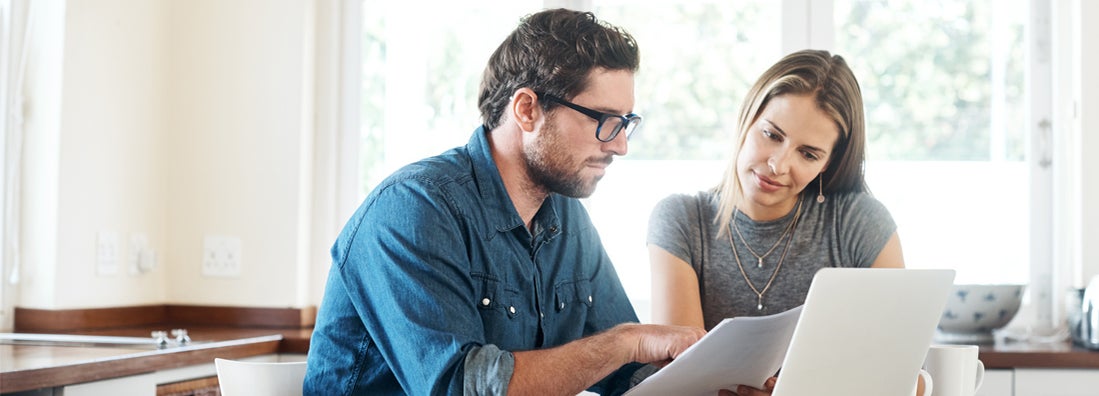 Shot of a young couple comparing umbrella insurance together