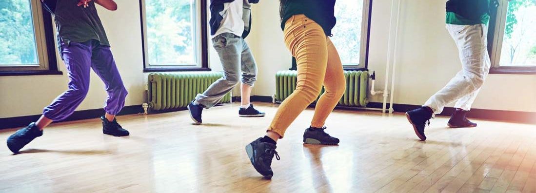 Group of people dancing together in a studio. Find Dance Studio Insurance.