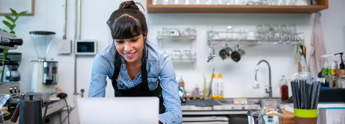 Barista using laptop for take order from customer. Find Shaker Heights, Ohio business insurance.