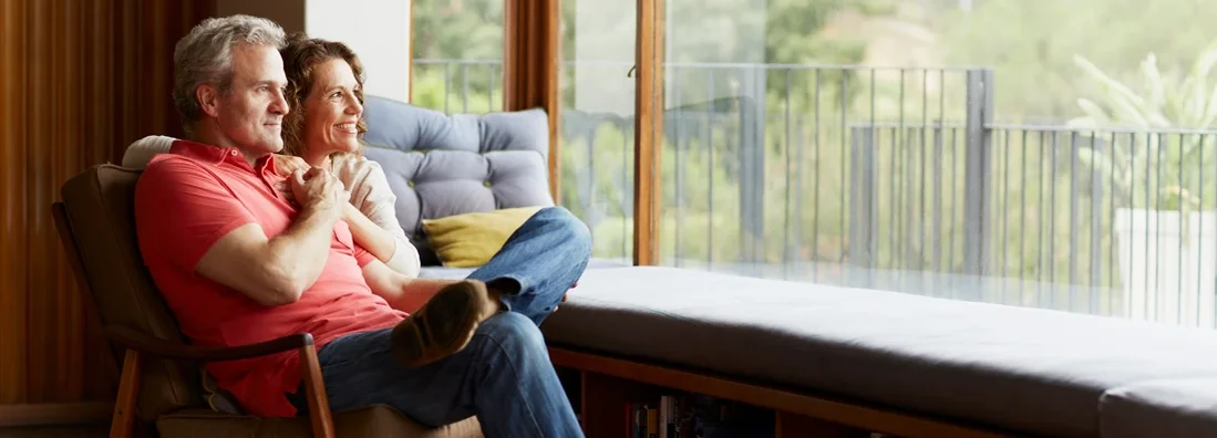Thoughtful mature couple relaxing by window at home. 7 Delightful Upsides to Downsizing.