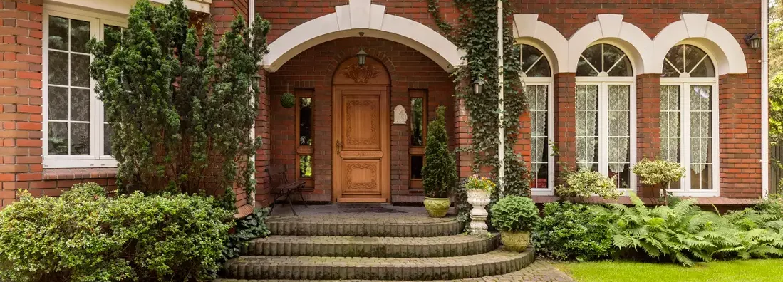 Cobbled path and steps leading to a stylish entryway in a red brick mansion. How to Find the Best Homeowners Insurance in Mt. Lebanon, Pennsylvania.