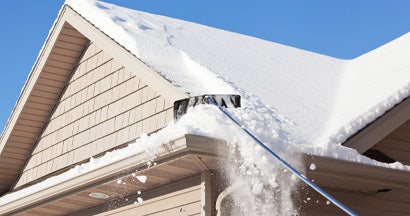 Roof Rake Removing Winter Snow. Is Too Much Snow on Your Roof an Insurance Problem in South Dakota?