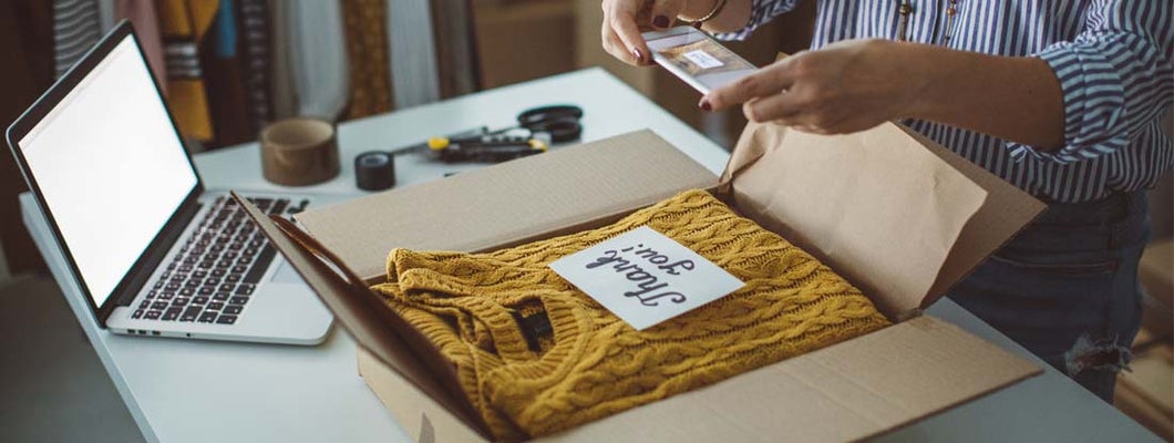 Small business owner packing product in boxes, preparing it for delivery.