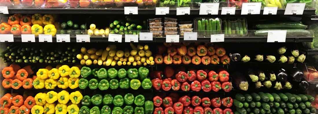 Fresh vegetables in the refrigerated section of a supermarket. Find grocery store insurance.