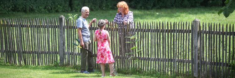 Grandparent and girl with neighbor in garden