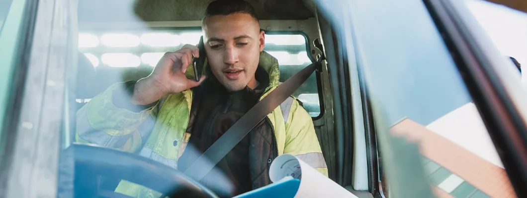 Worker is sitting in his van, looking through paperwork. Kentucky Commercial Vehicle Insurance.