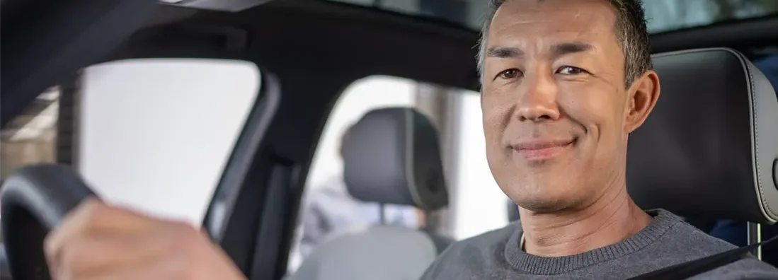 Smiling man driving his car. Find Middleton, Delaware car insurance.