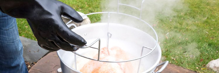 Deep fried Thanksgiving turkey being taken out of fryer 