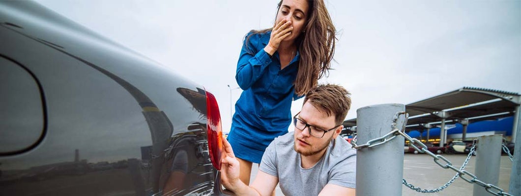 Man and woman examining damage in car collision. Find Collision Insurance.