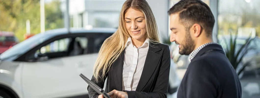 Saleswoman showing customer car performance on tablet. Tips for Test Driving a Car. 