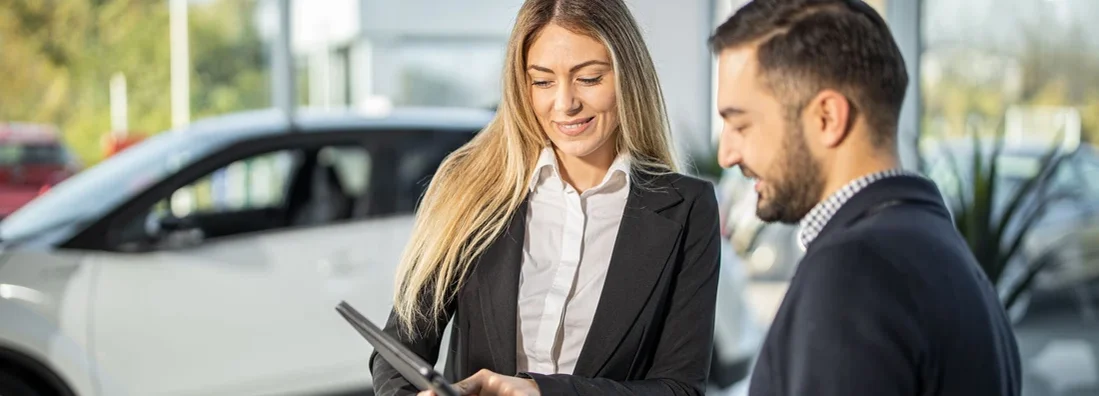 Saleswoman showing customer car performance on tablet. Tips for Test Driving a Car. 