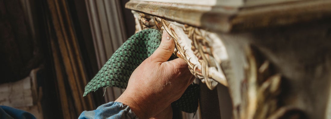 Polishing an antique restored table. Find antique furniture restoration service insurance.