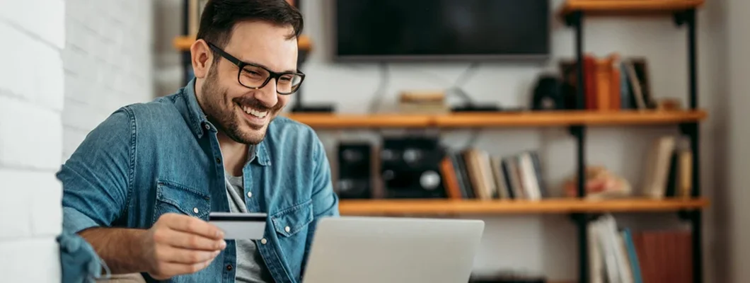 Man with laptop and credit card at home. A Safety-Lover’s Guide to Protected Online Shopping. 