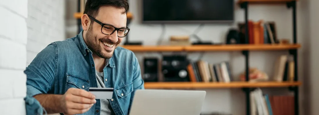 Man with laptop and credit card at home. A Safety-Lover’s Guide to Protected Online Shopping.
