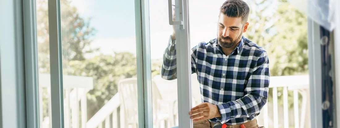 Man installing bay window in a new house construction site. Find door and window installation insurance.