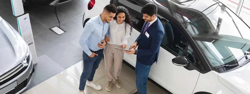 Customers having conversation with sales assistant, leasing a car. How to lease a car.