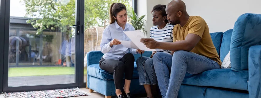 Couple buying a house and reviewing the contract with their real estate agent. Do You Need Renters Insurance?