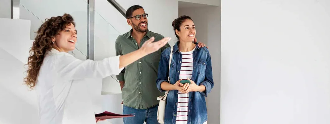 Landlord showing new apartment to happy young couple. Find Alaska Landlord Insurance.