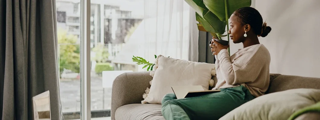 Young woman having coffee and relaxing in apartment. What Does Renters Insurance Cover?