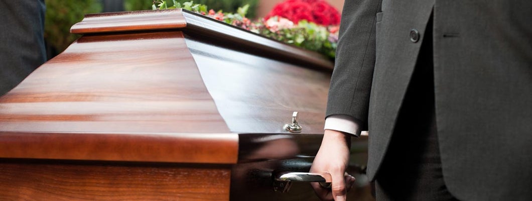 Casket carried by coffin bearer at funeral. Find Funeral Home Insurance.