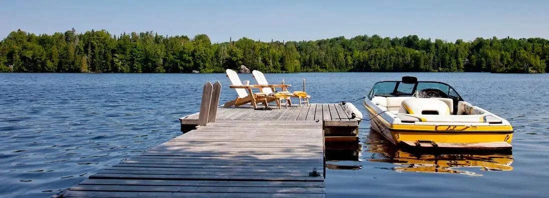 Two Adirondack chairs on Sunny Dock with Wakeboard boat. Find Indiana Boat Insurance.