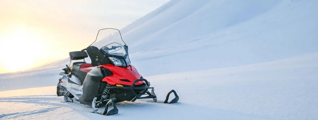 Red snowmobile on a background of snowy mountains. Customizing Your Snowmobile.