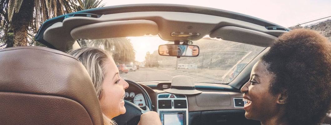 Happy girls having fun in convertible car in San Diego. Find San Diego California car insurance.