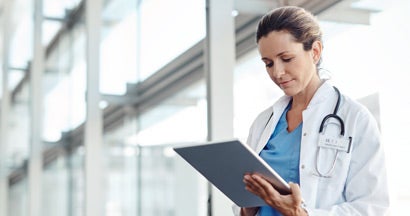 Female doctor using a digital tablet. Find Professional Liability Insurance for Doctors.