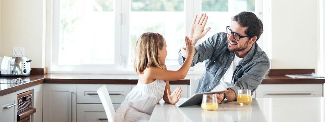 Shot of little girl using a digital tablet with her father at home