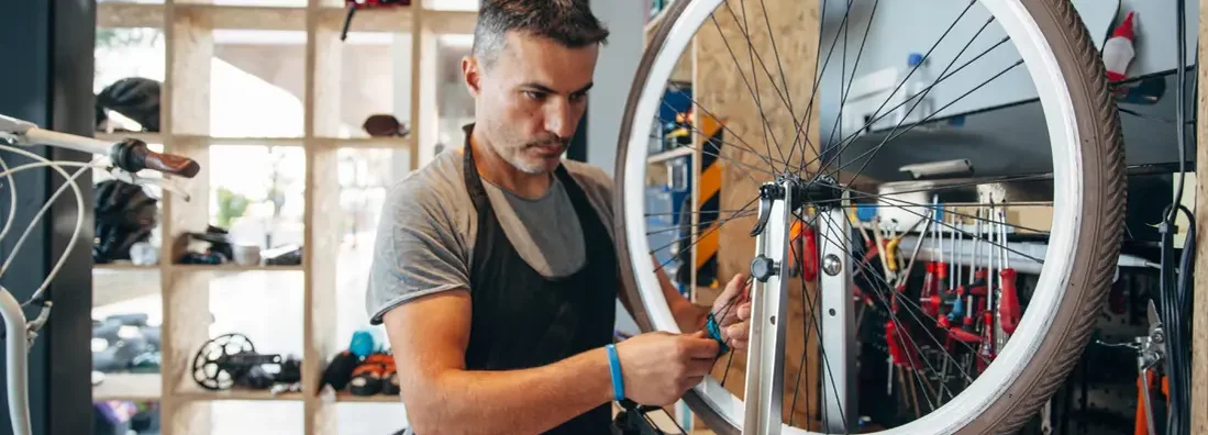 Bicycle service shop owner working on bike at bicycle. Find Parkland, Florida business insurance.