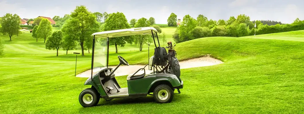 Golf cart on green course with blue sky. Find Golf Cart Insurance.