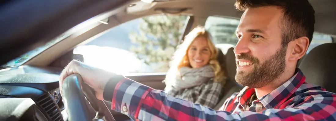 Couple in the car traveling together. Find Rogers, Arkansas car insurance.