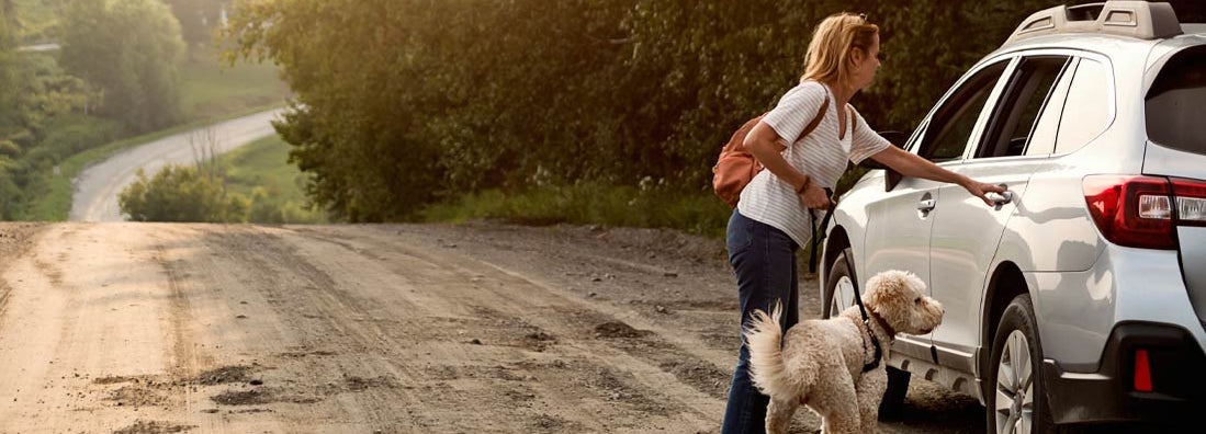 Woman going back to car after a walk with dog. Find Greensboro North Carolina car insurance.