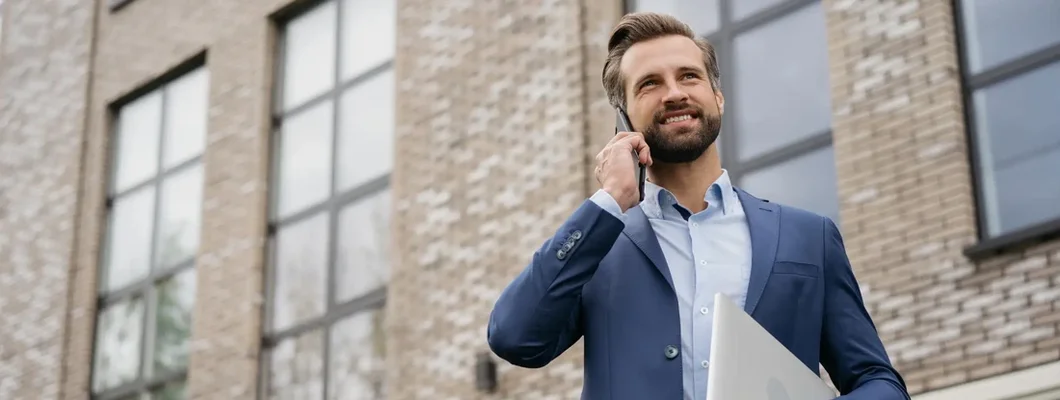 Landlord talking on mobile phone standing on the street. Find Michigan Landlord Insurance.