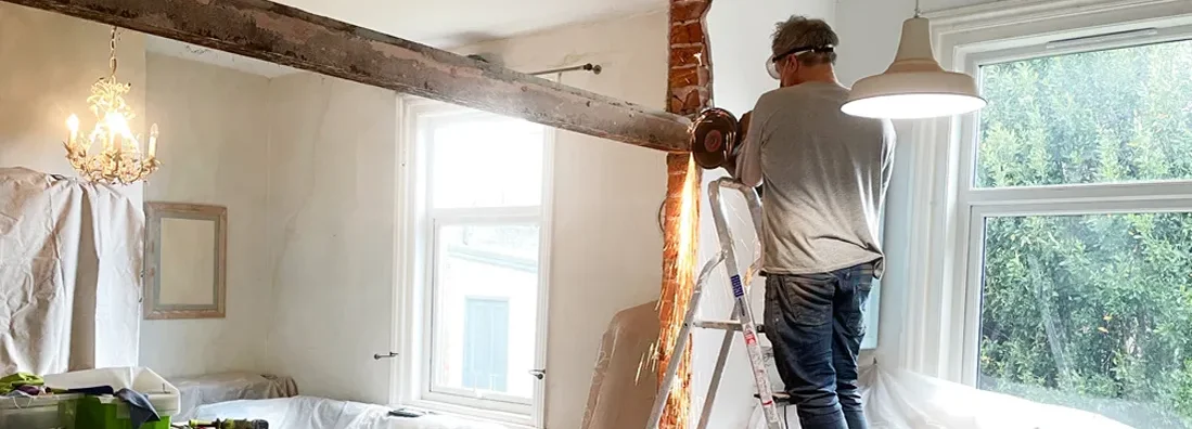 Man removing a metal beam during home renovation. If I Renovate My Home In New Jersey, Should I Call My Insurance Agent?